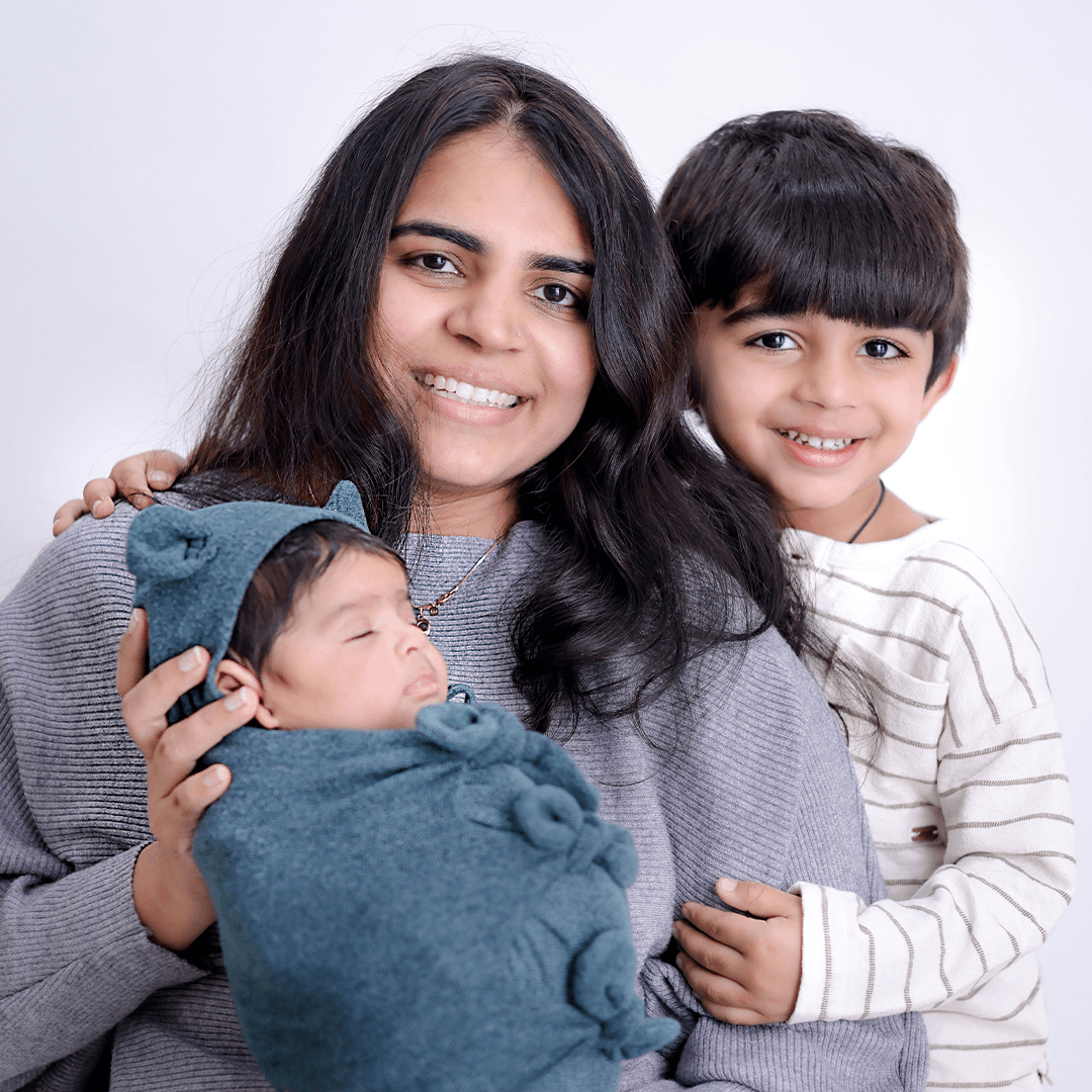 Mother with her baby and young son smiling together