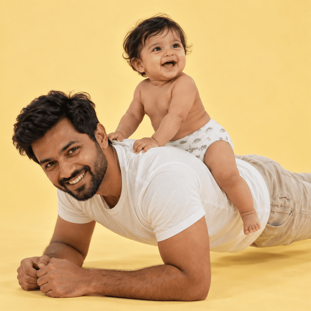 Baby riding piggyback on father's shoulders, wearing a Lumi9 diaper