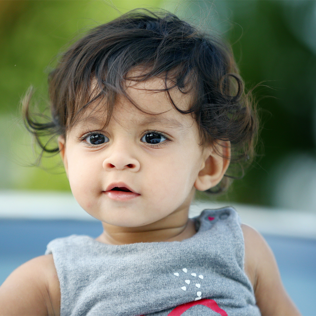 Close-up of a curly-haired toddler outdoors